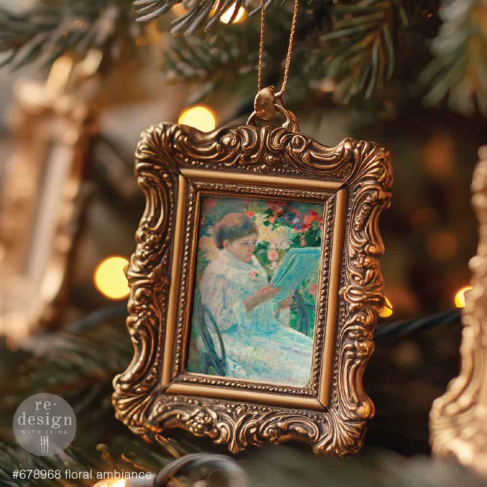 Decorative ornament with vintage-style frame and painting inside, hanging on a Christmas tree.