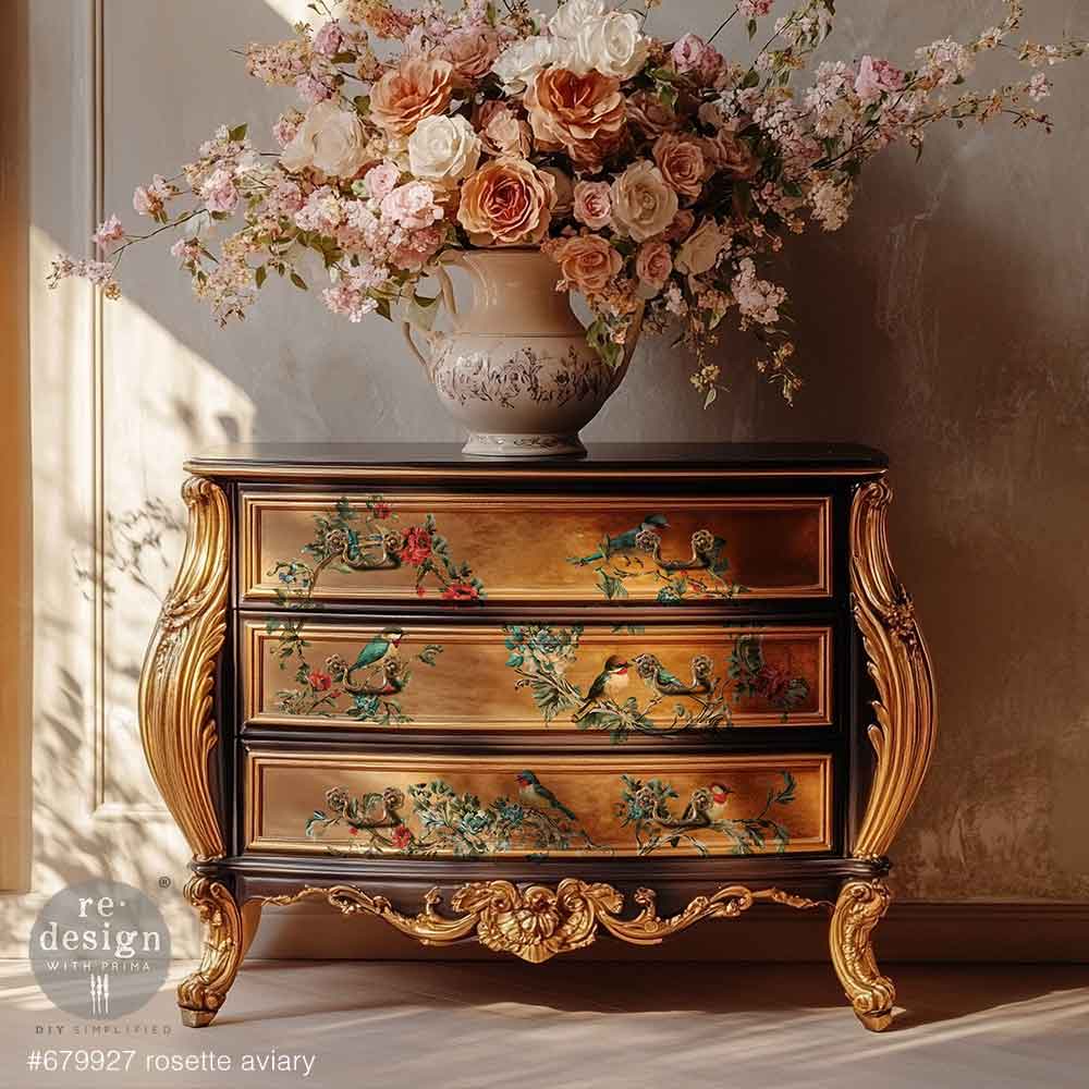 Decorative chest of drawers with floral design next to a vase of flowers.