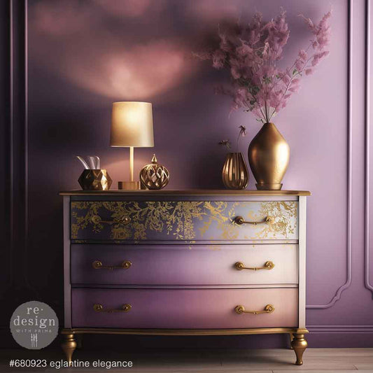 Decorative chest of drawers with gold accents and a vase of flowers against a purple wall.
