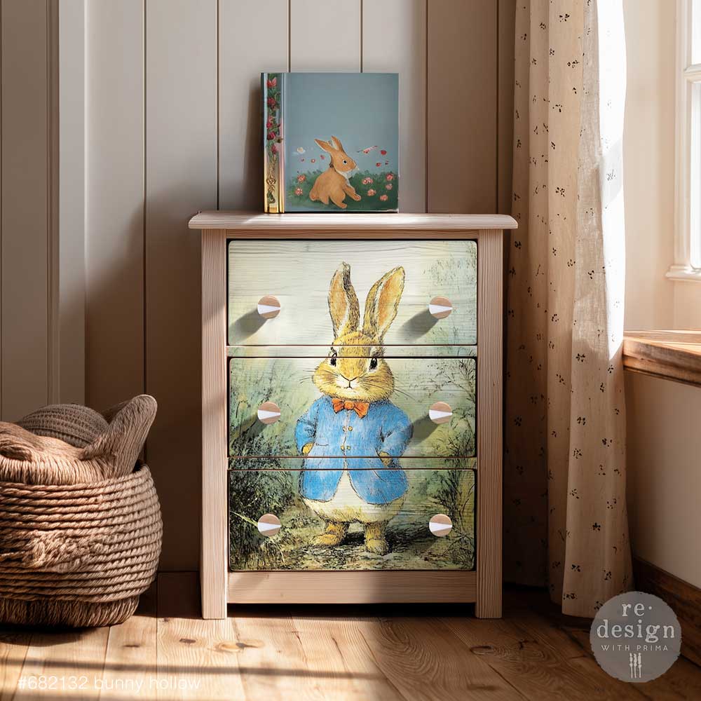 A dresser is shown with the Bunny Hollow decoupage fiber in a nursery room setting.