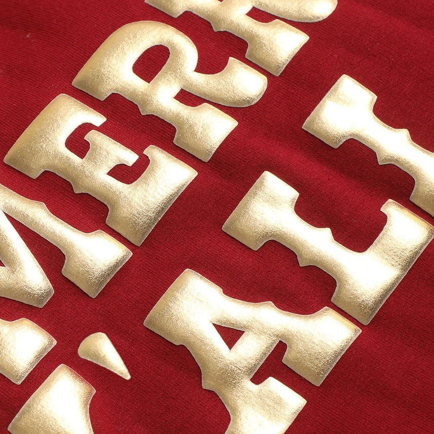 Close up of gold lettering on sweatshirt