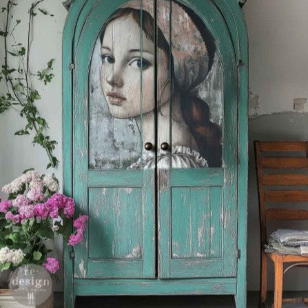 Vintage turquoise cabinet with a painted portrait on one of the doors, surrounded by flowers and a chair.