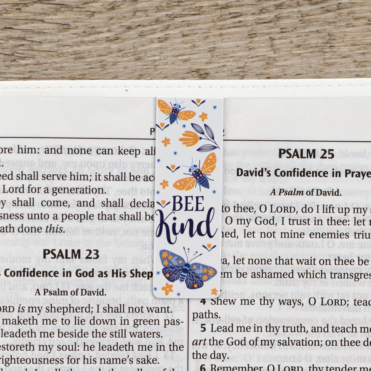Bookmark with butterfly design and 'Bee Kind' text on a Bible