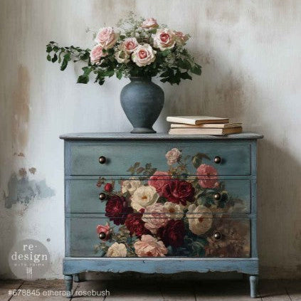 Decorative chest of drawers with floral design and a vase of flowers on top against a textured wall.