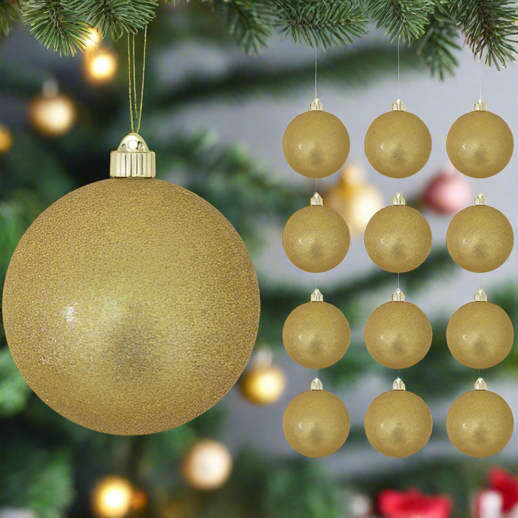 Gold Christmas ornaments hanging on a tree with blurred lights in the background