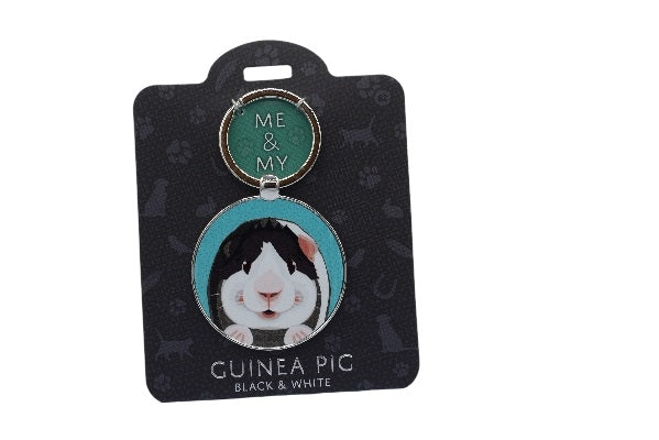 Keychain with a guinea pig design on a black card with cat illustrations