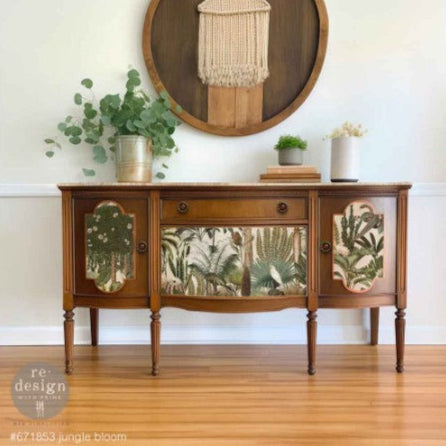 Wooden sideboard with decorative glass panels in a room with plants and a mirror.