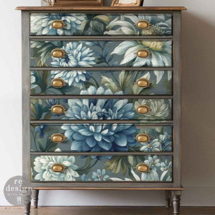 Wooden dresser with floral drawer fronts and gold knobs on a plain background