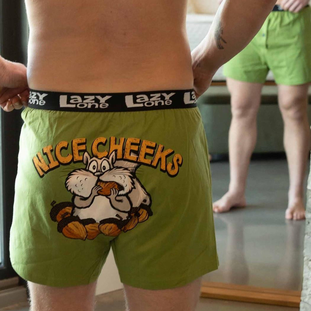 Person wearing green boxer briefs with cartoon design and 'Lazy One' brand logo.