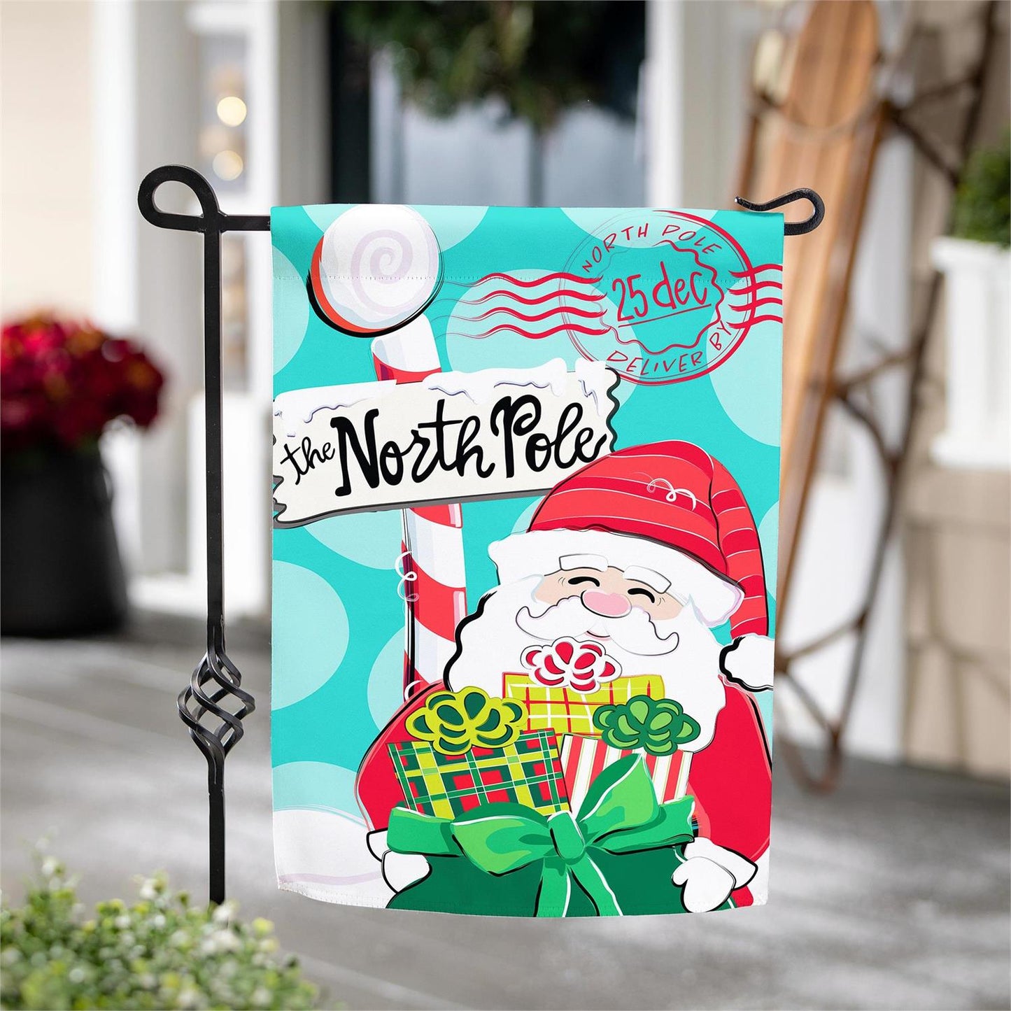 Decorative garden flag with Santa Claus and 'The North Pole' text, featuring a festive design.