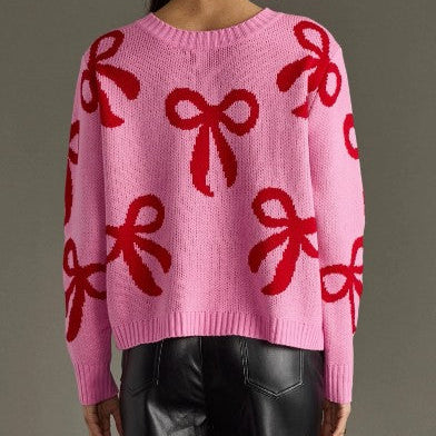 Pink sweater with red bows on a gray background