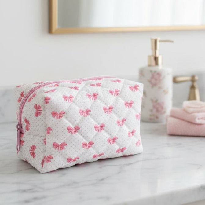 White pouch with pink butterfly patterns and a zipper on a bathroom counter