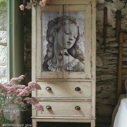 Vintage cabinet with a decorative face on one of the doors, set against a stone wall.