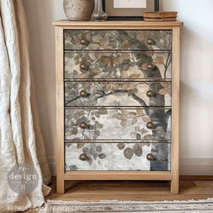 Wooden dresser with floral glass panels and metal knobs in a room setting.