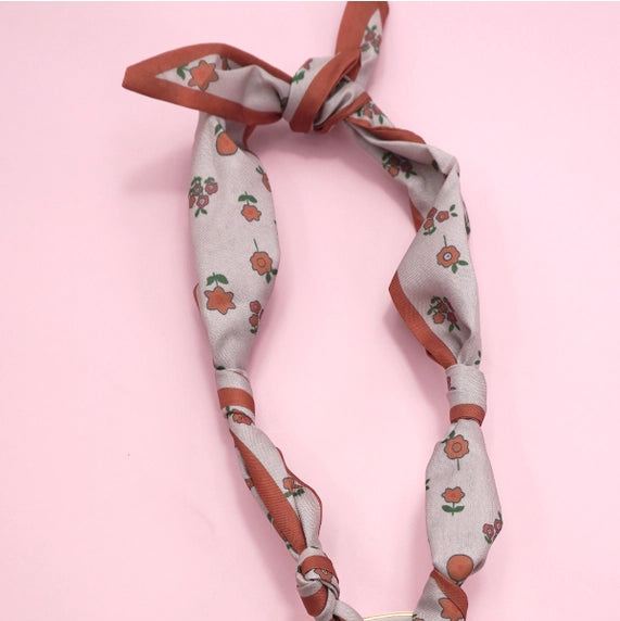 Decorative headband with floral pattern on a pink background