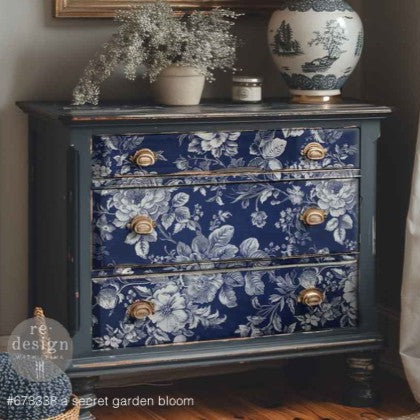Blue floral-patterned dresser with gold knobs in a room setting.