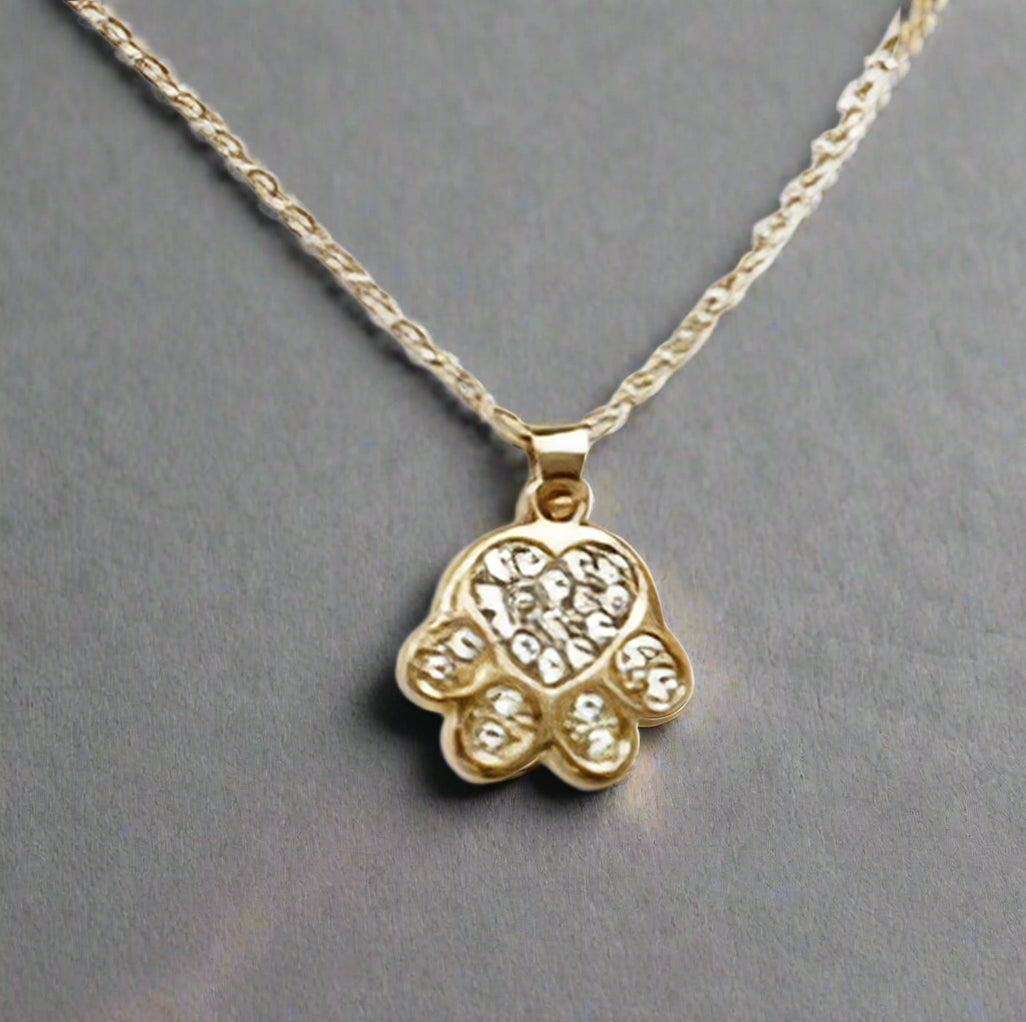 Gold necklace with a hamsa hand pendant on a white background