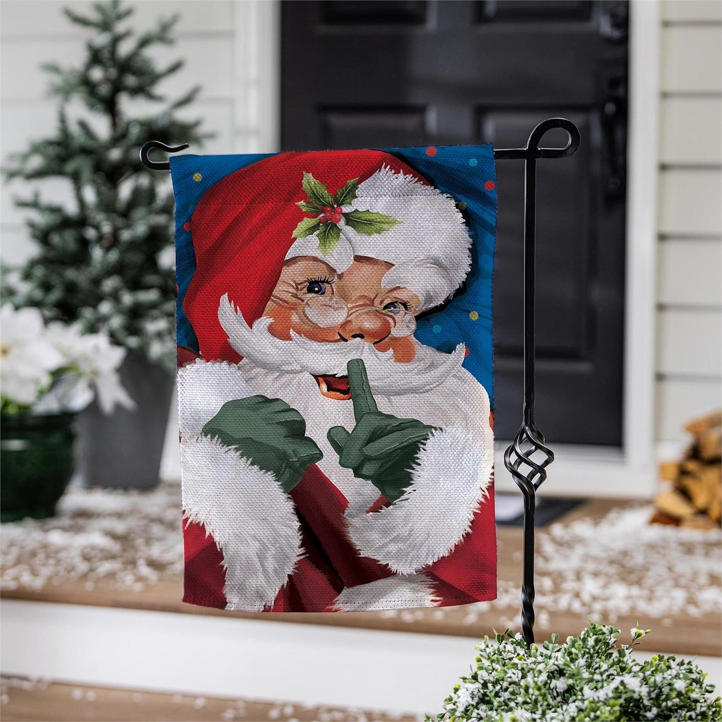 Decorative garden flag with a humorous vintage Santa Claus design outdoors.