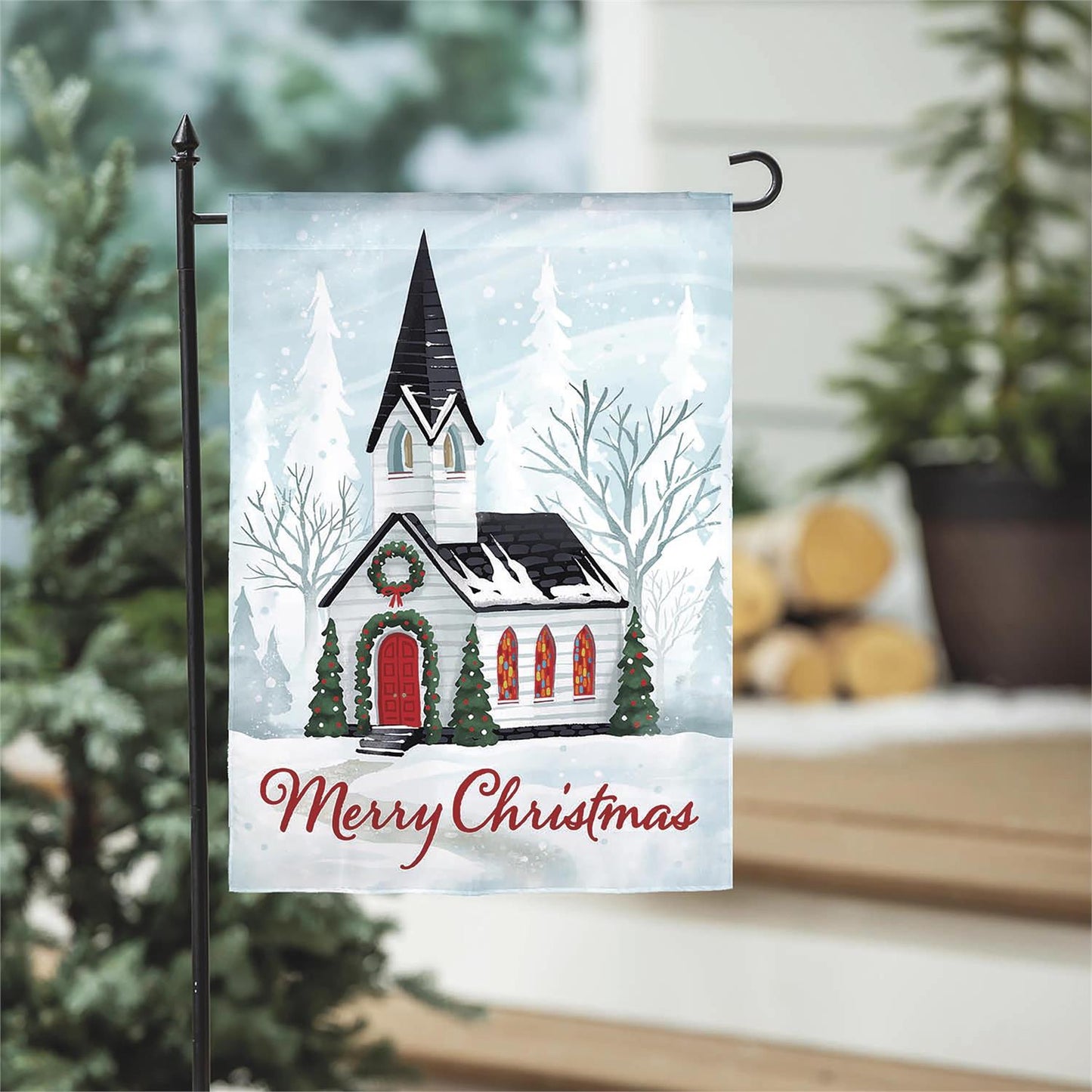 Christmas-themed garden flag with a church design and 'Merry Christmas' text, displayed outdoors.
