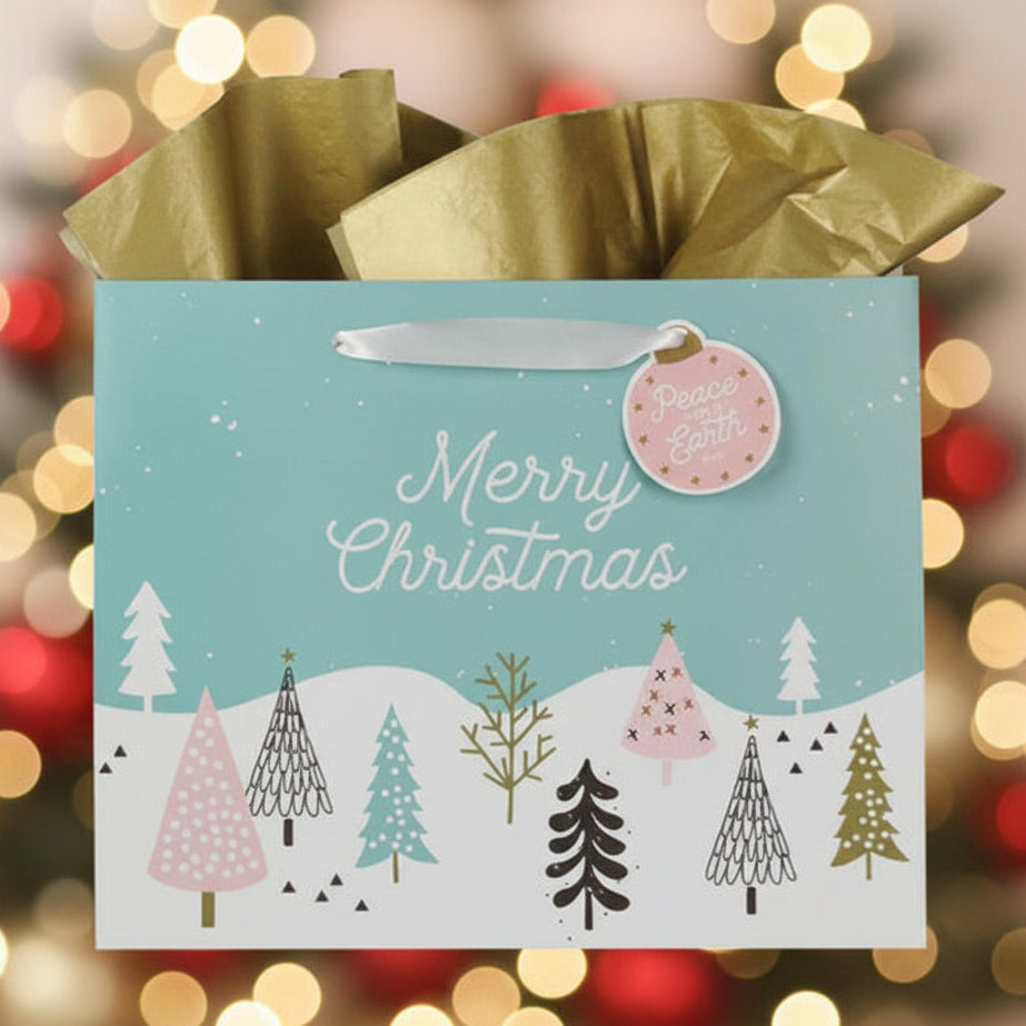 Christmas gift bag with festive trees design against a blurred Christmas lights background