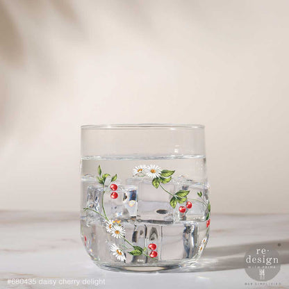 Clear glass tumbler decorated with Daisy Cherry Delight Luxe Transfers on a light background