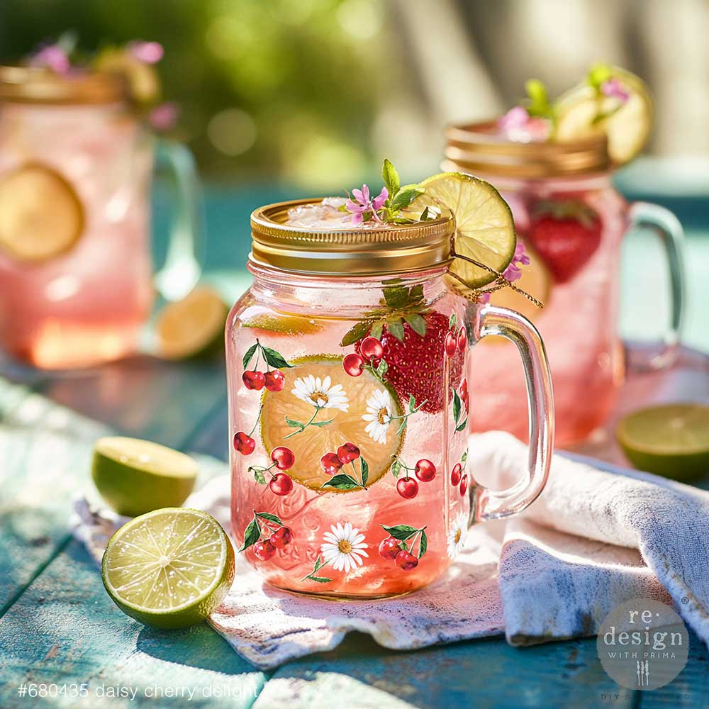 Mason jar mug with pink lemonade decorated with Daisy Cherry Delight Luxe Transfers on a blue wooden table.