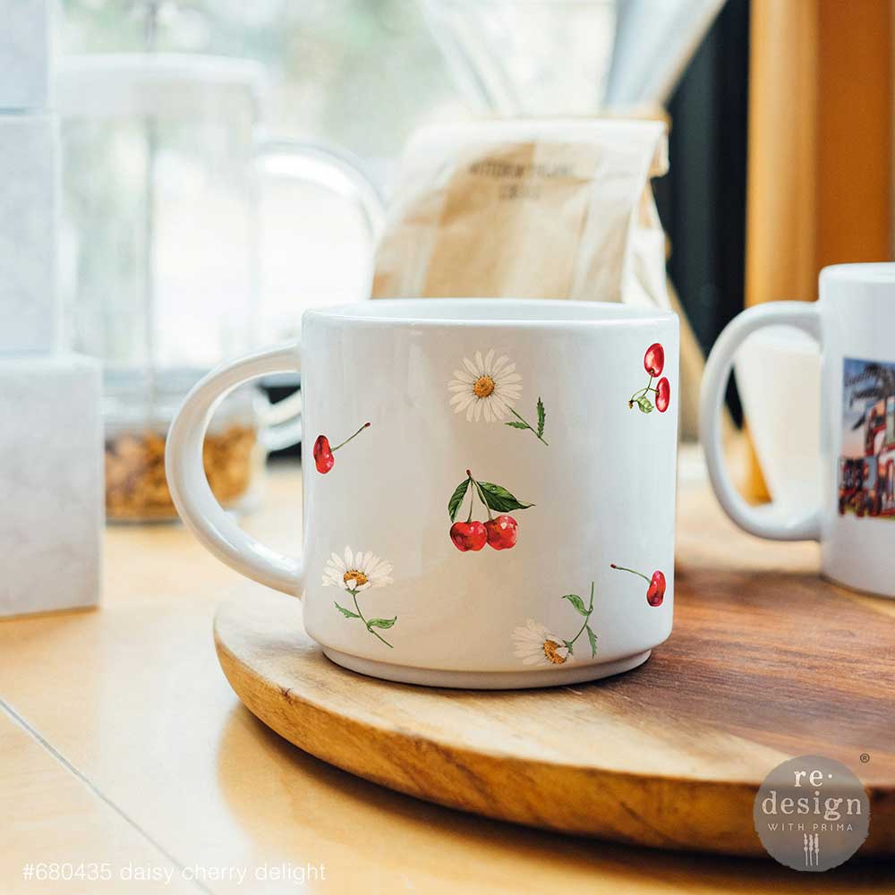 White mug decorated with Daisy Cherry Delight Luxe Transfers on a wooden surface