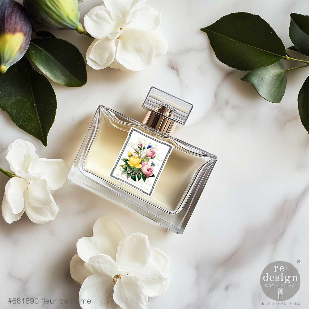 Perfume bottle with Fleur De Frame Luxe Transfers on a marble surface with flowers and leaves