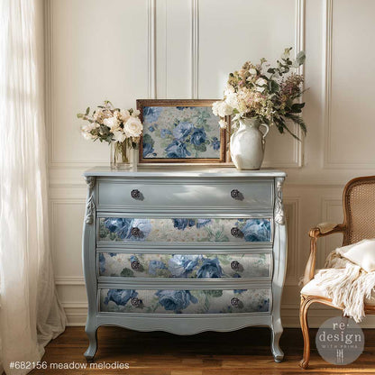 Meadow Melodies decoupage paper is featured on a light blue dresser in a room with flowers and a chair.