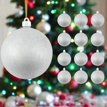 Decorative Christmas ornaments including a large silver glittery ball and smaller white balls against a festive tree background.