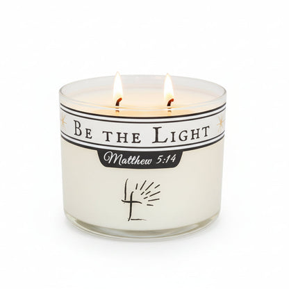 Candle with 'Be the Light Matthew 5L:14' message on a white background.