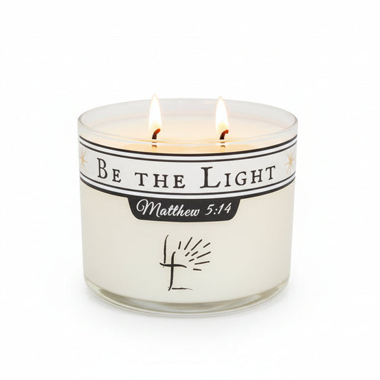 Candle with 'Be the Light Matthew 5L:14' message on a white background.