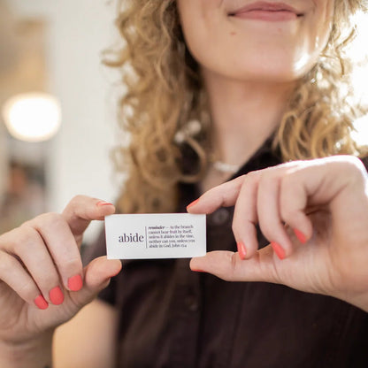 Person holding a white card with text, blurred background