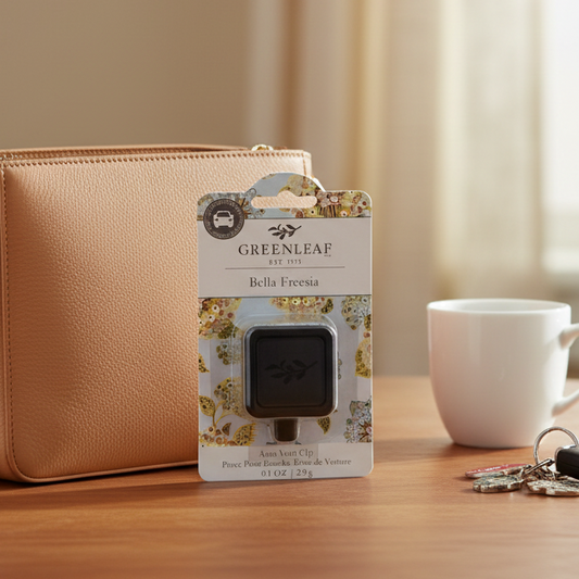 Greenleaf Bella Freesia auto vent clip with a purse, coffee cup, and car keys on a table.
