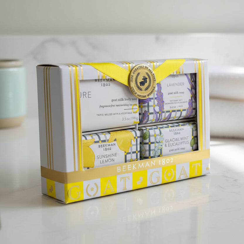 Beekman 1802 Goat Milk Soap four bar gift set on a bathroom counter. Scents include Glacial Mint & Eucalyptus, Lavender, Pure, and Sunshine Lemon.
