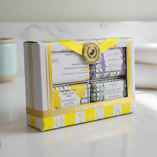 Beekman 1802 Goat Milk Soap four bar gift set on a bathroom counter. Scents include Glacial Mint & Eucalyptus, Lavender, Pure, and Sunshine Lemon.