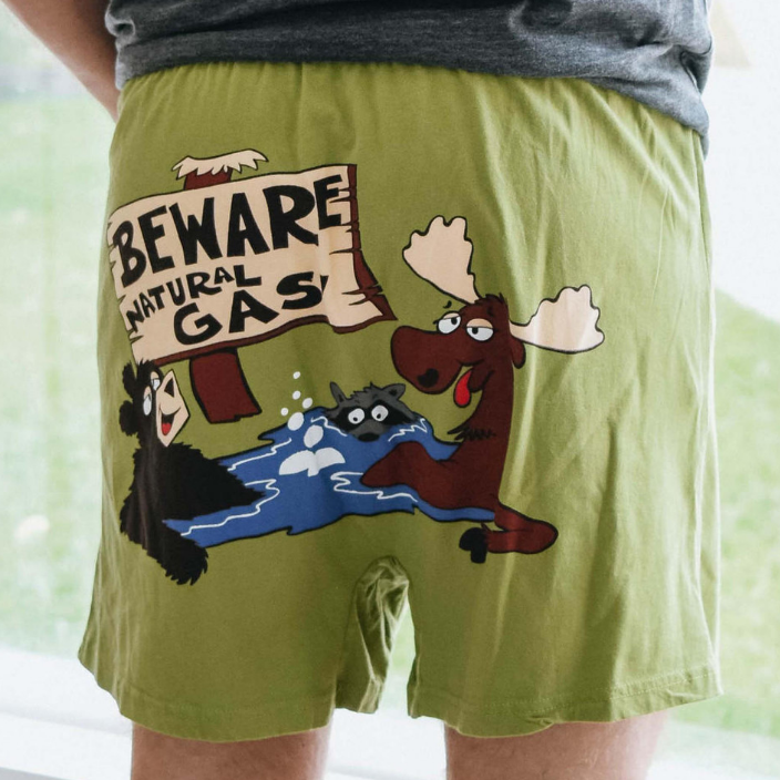Green shorts with cartoon design featuring a moose and bear, and 'Beware Natural Gas' sign