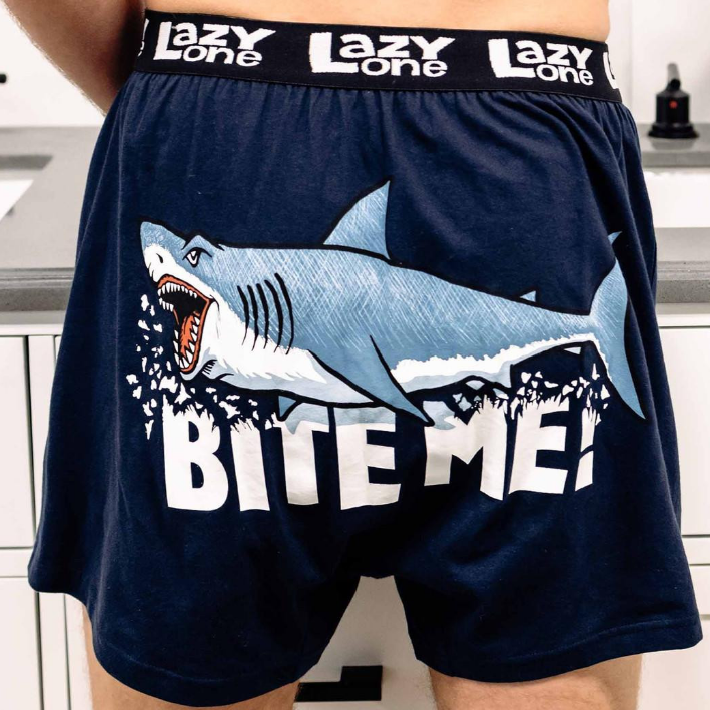 Navy blue boxer briefs with shark graphic and 'BITE ME!' text, brand 'Lazy One' visible.