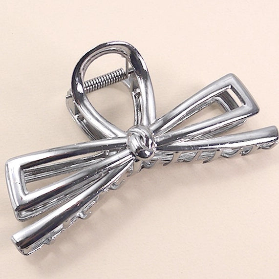 Hematite bow-shaped hair clip on a beige background