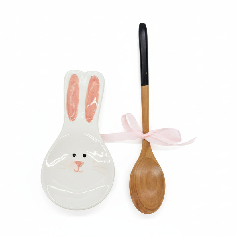 Ceramic rabbit-shaped spoon rest and wooden spoon on a white background