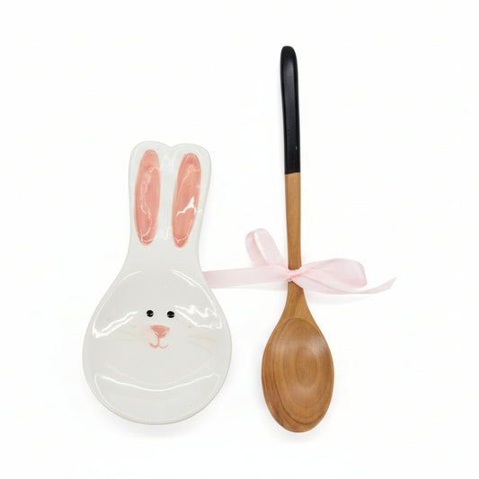 Ceramic rabbit-shaped spoon rest and wooden spoon on a white background