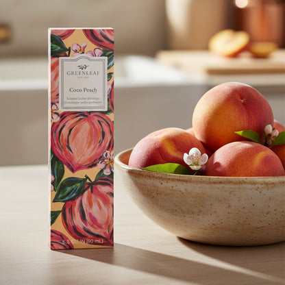 Greenleaf Coco Peach slim sachet on a kitchen counter next to a bowl of peaches.