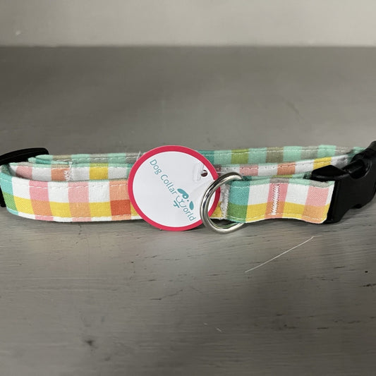 Checkered dog collar with a tag on a gray surface