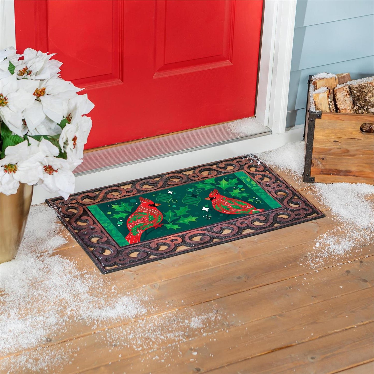 Decorative doormat with cardinals design on a wooden floor in front of a red door.