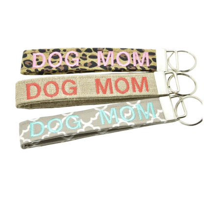 Three keychains embroidered with DOG MOM on leopard print, burlap style, and quatrefoil fabric on a white background.