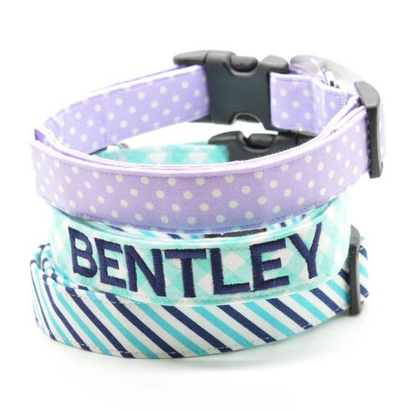 Dog collar with purple polka dot top section and blue striped bottom section on a white background