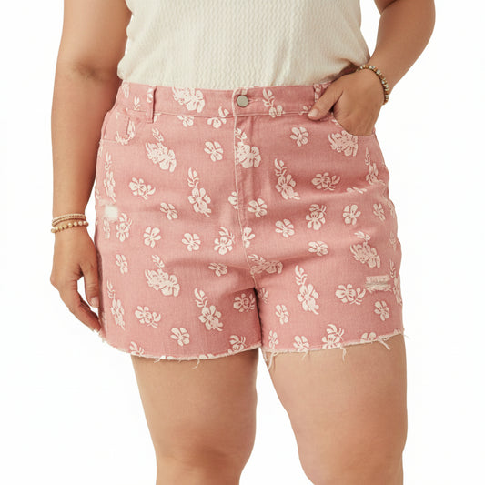 Pink floral shorts worn by a person on a plain background