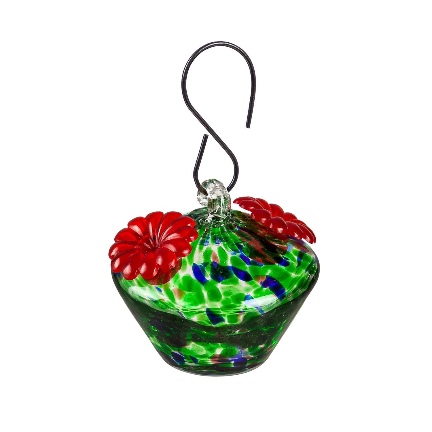 Glass hummingbird feeder with red flowers and green base on a white background