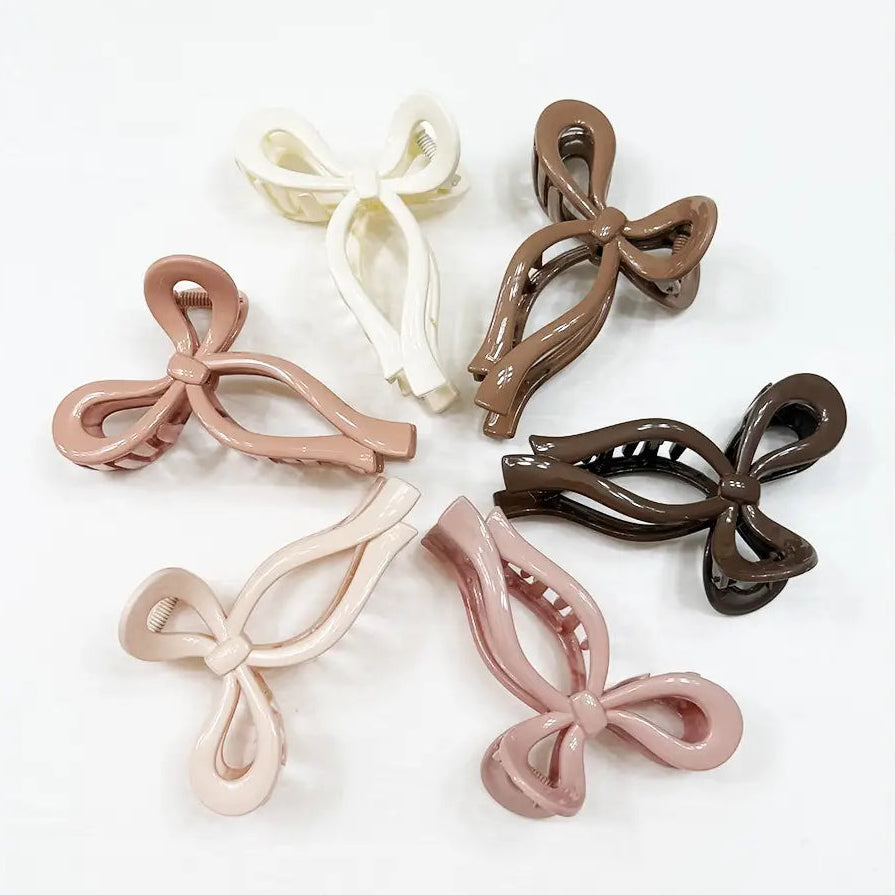 Bow-shaped hair clips in various colors on a white background
