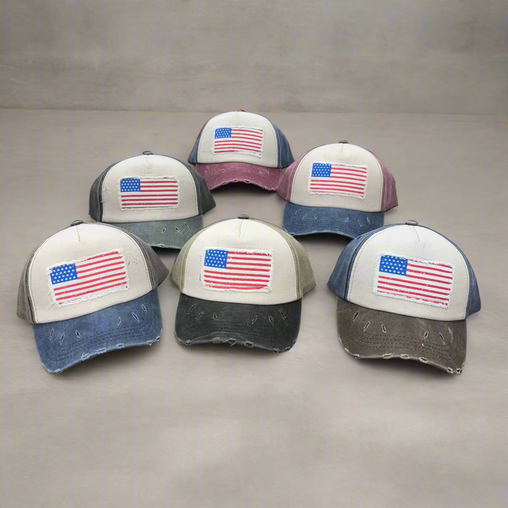 Six caps with American flag designs on a table.